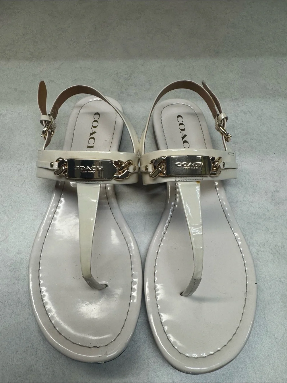 Coach Ivory Patent Leather T‑Strap Sandals with Gold Plaque